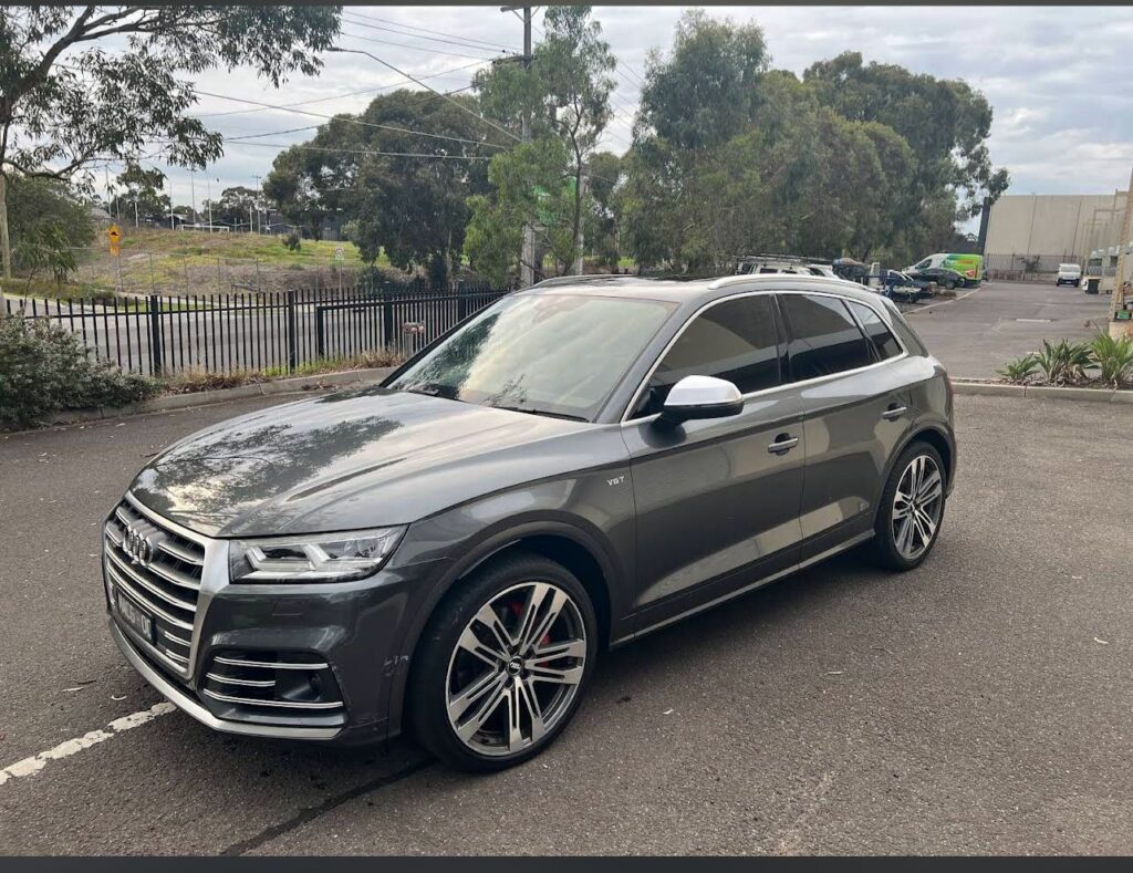 Professional car detailing technician cleaning vehicle exterior
