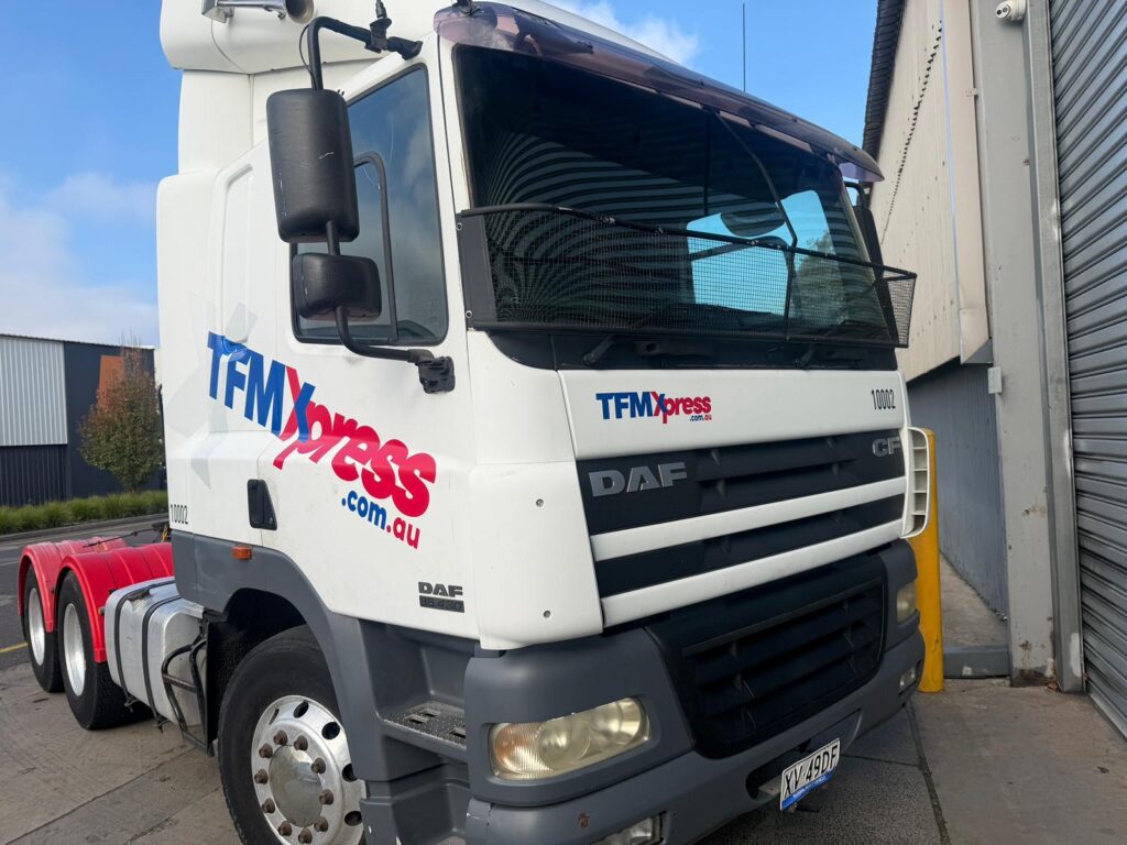 Before truck signage removal showing old business branding, vinyl decals and company stickers on a DAF truck in Melbourne.